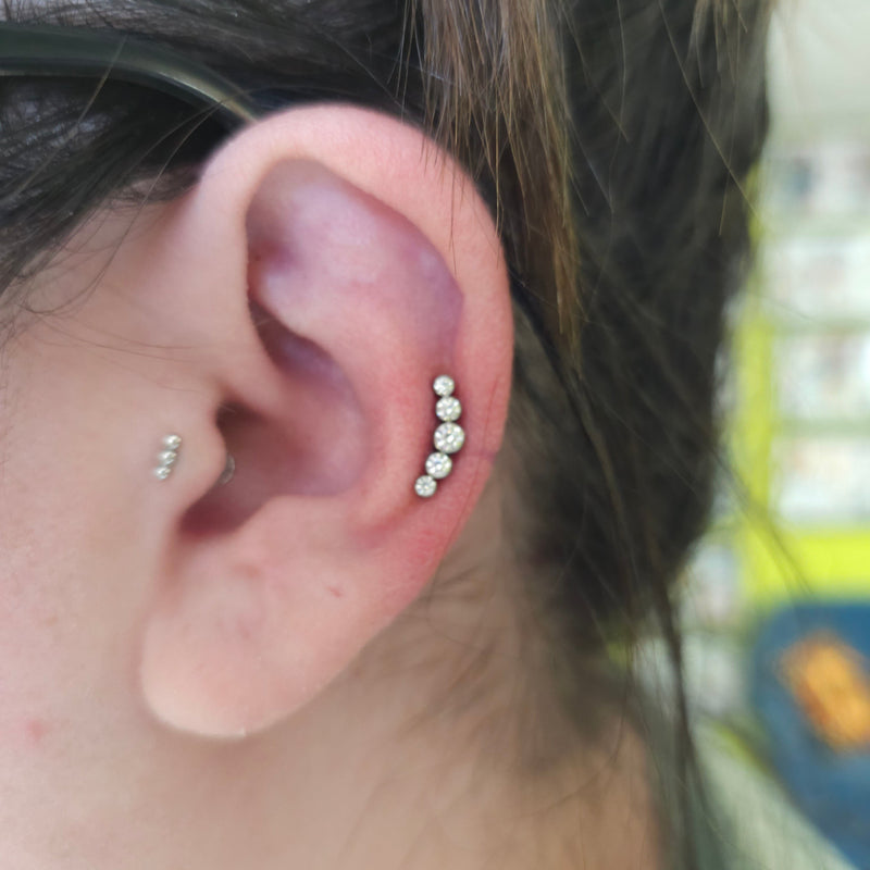 Close-up of an ear with multiple diamond stud earrings.